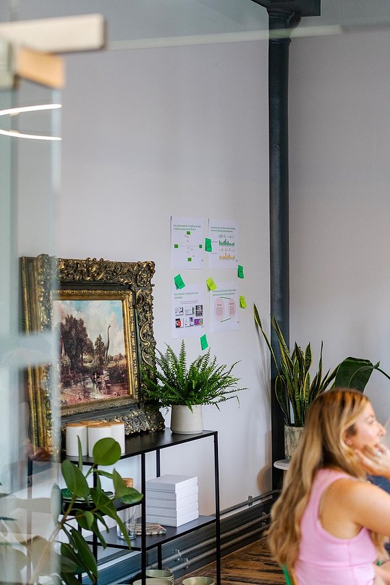 commercial lifestyle photography showing cropped view of meeting room with picture in antique frame and plants