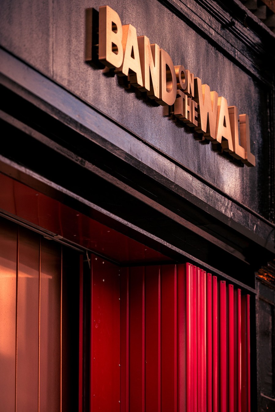 placemaking photography. manchester. norther quarter. architecture. venue. signage of band on the wall