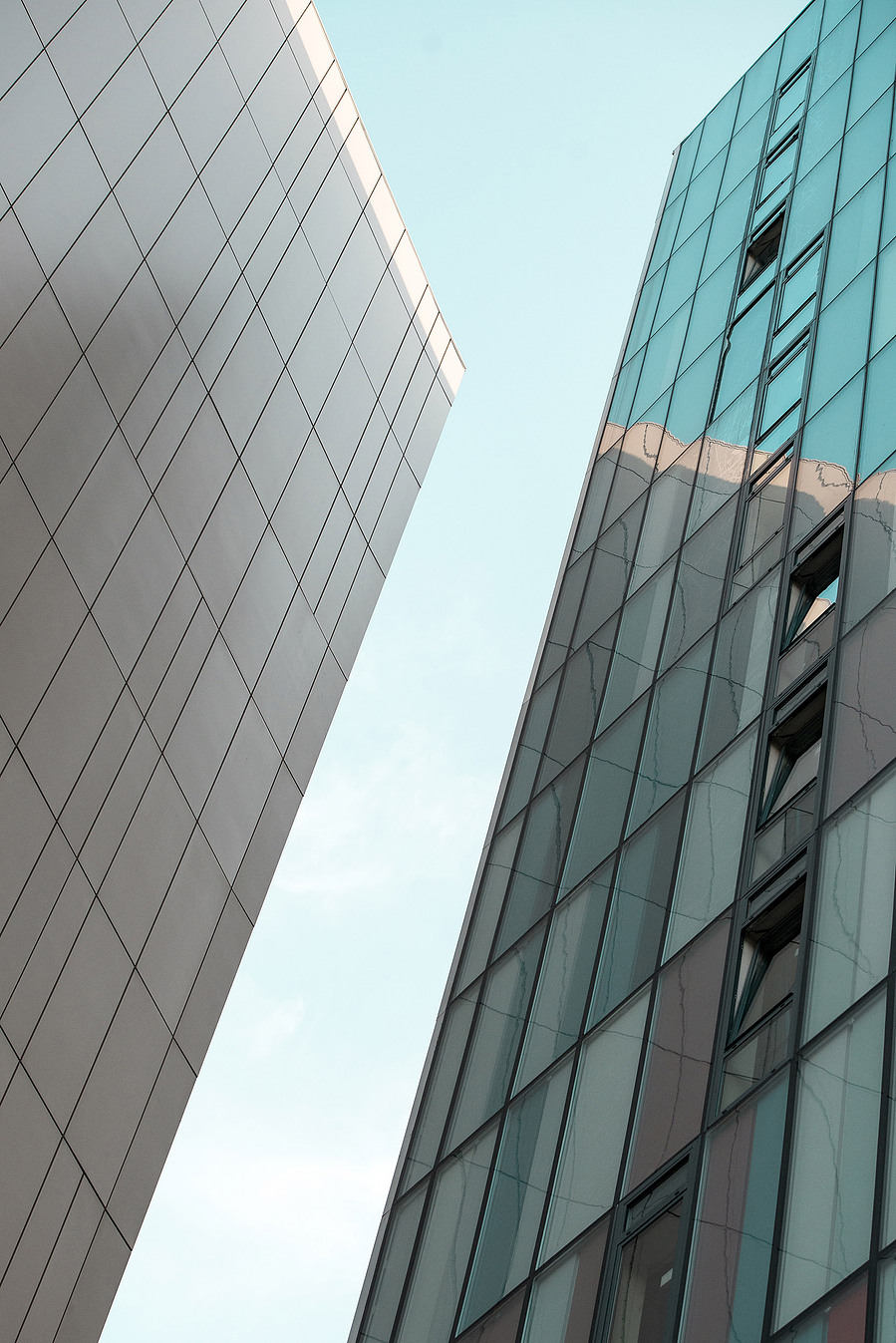 cropped image of modern city buildings against blue sky