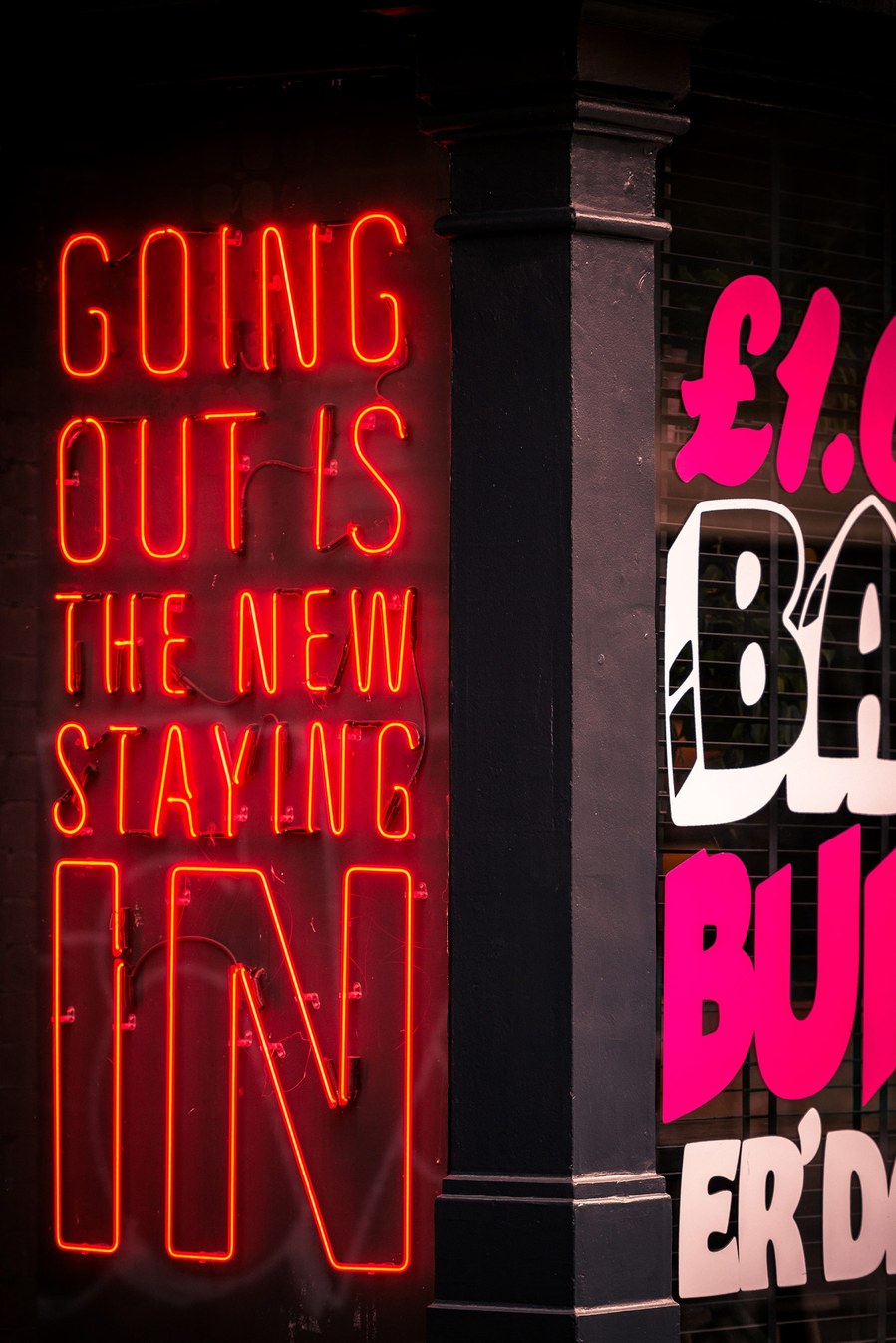neon sign saying going out is the new staying in. manchester northern quarter