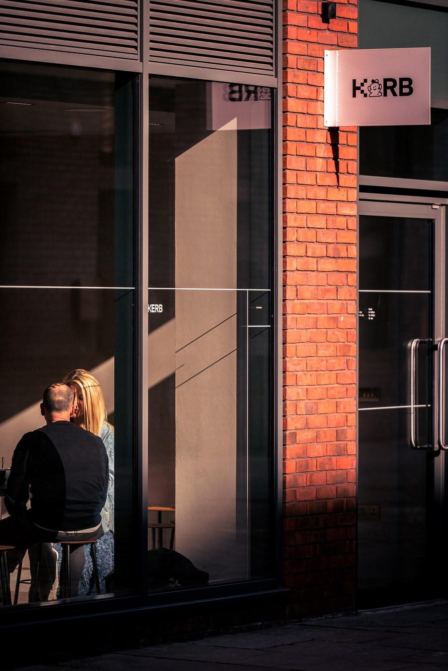 placemaking photography. manchester. norther quarter. architecture. ancoats, couple sit in window of wine bar 