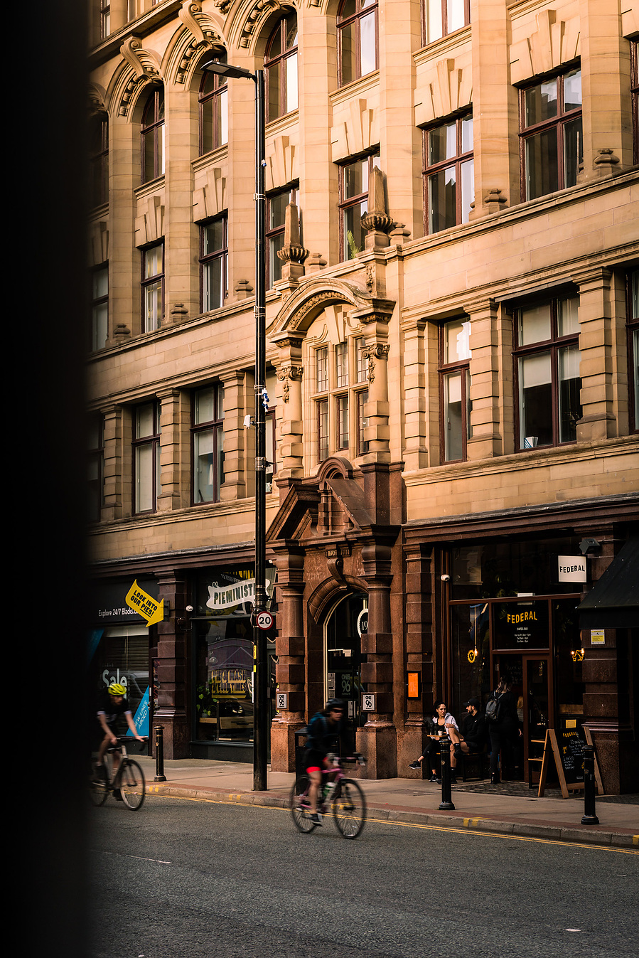 classic manchester architecture. city centre building. photographed with shadows across frontage of brickwork. people on street