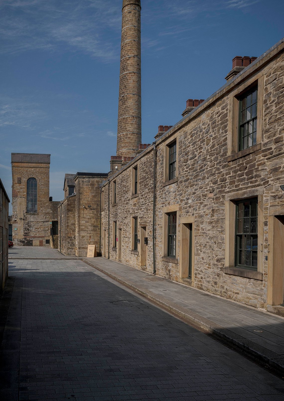  Exterior of Root Fifty-Two's office in Burnley, showing a row of stone terraced buildings. A signboard at the entrance reads 'We Elevate Brands,' highlighting the agency’s historic and inviting location.