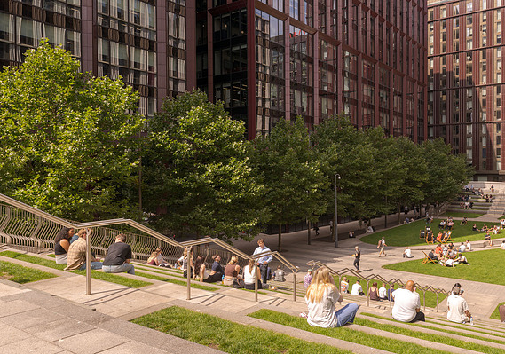 Commercial architecture and lifestyle photography shows circle square in Manchester with high rise buildings and people using shared open space
