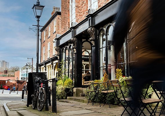 Case Study Photography Cover For Local Area And Urban Lifestyle Photography For Stockport Property Developers showing a cafe exterior and a cyclist 