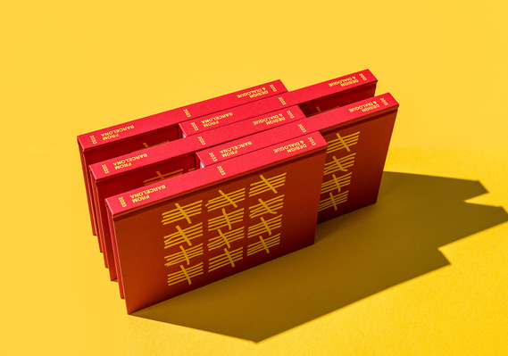Red books arranged on a yellow background. Strong shadows