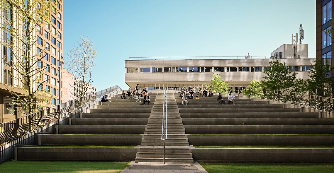 Students sit on steps outside MSA in architectural shot