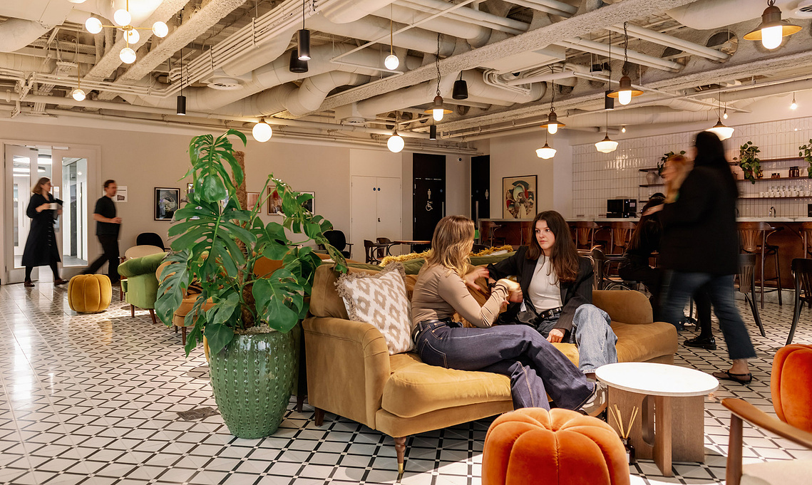 Relaxed workplace interaction candid marketing imagery, busy space with sofas and counter