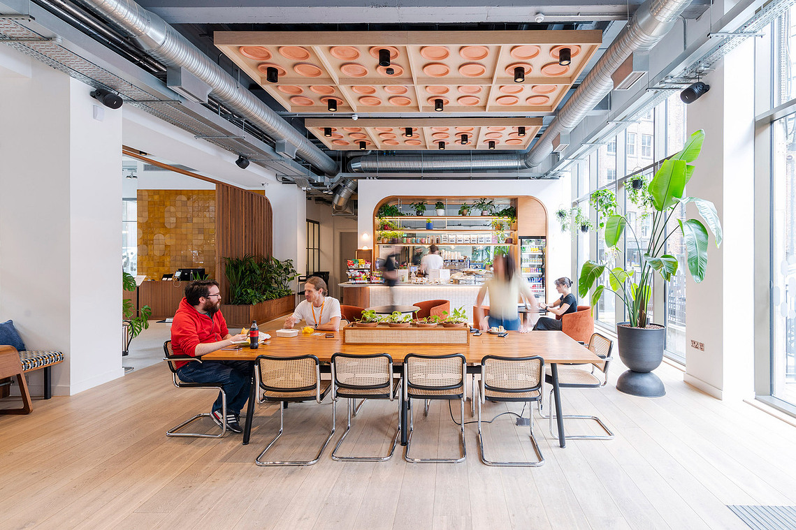 Authentic lifestyle photography of Clockwise Manchester club lounge with members socialising. Wide image of communal seating with lots of natural light