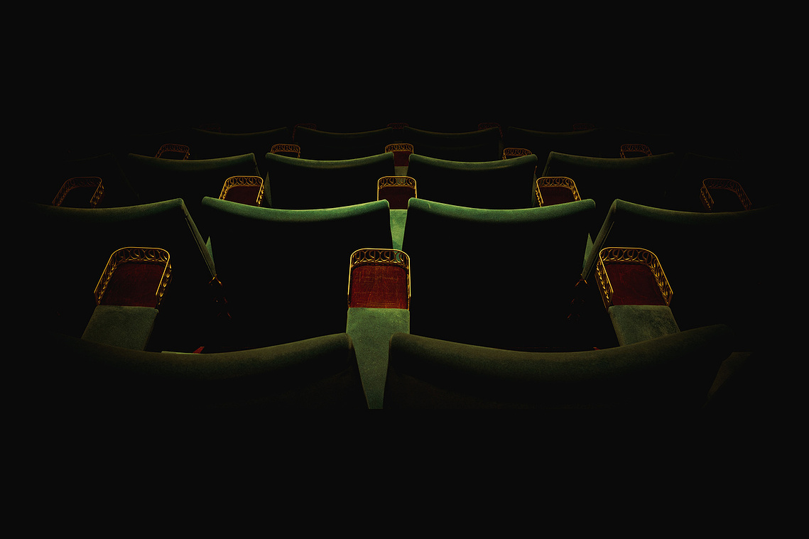 green velvet cinema seats, from behind, low lighting , moody, vintage 