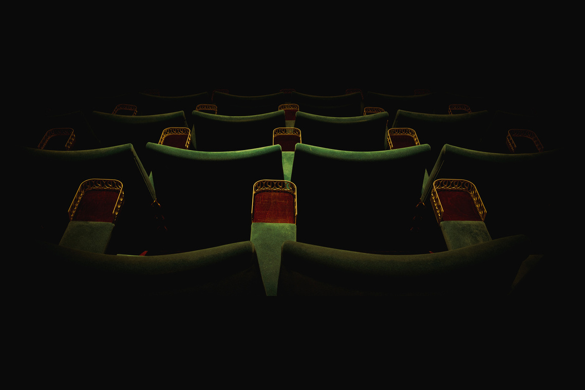 green velvet cinema seats, from behind, low lighting , moody, vintage 