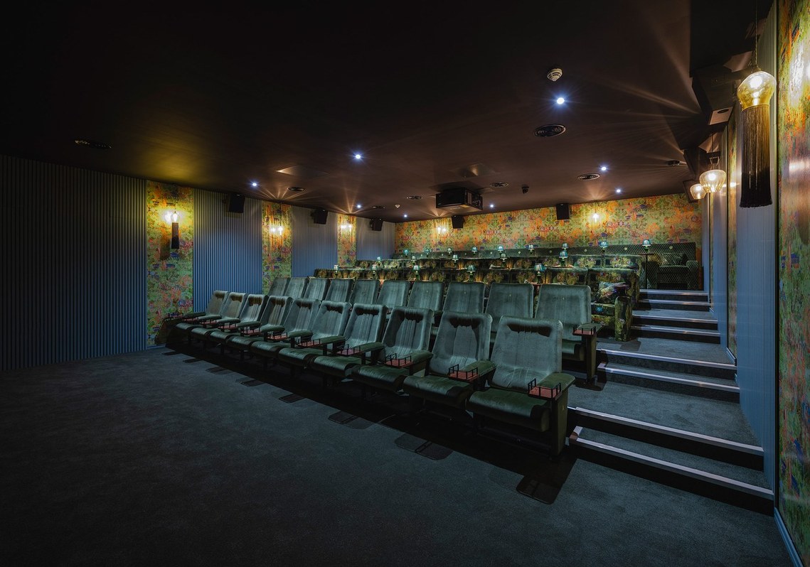 interior photography of cinema interior, auditorium with view of rows of seats, blue and green decoration and boutique lamps