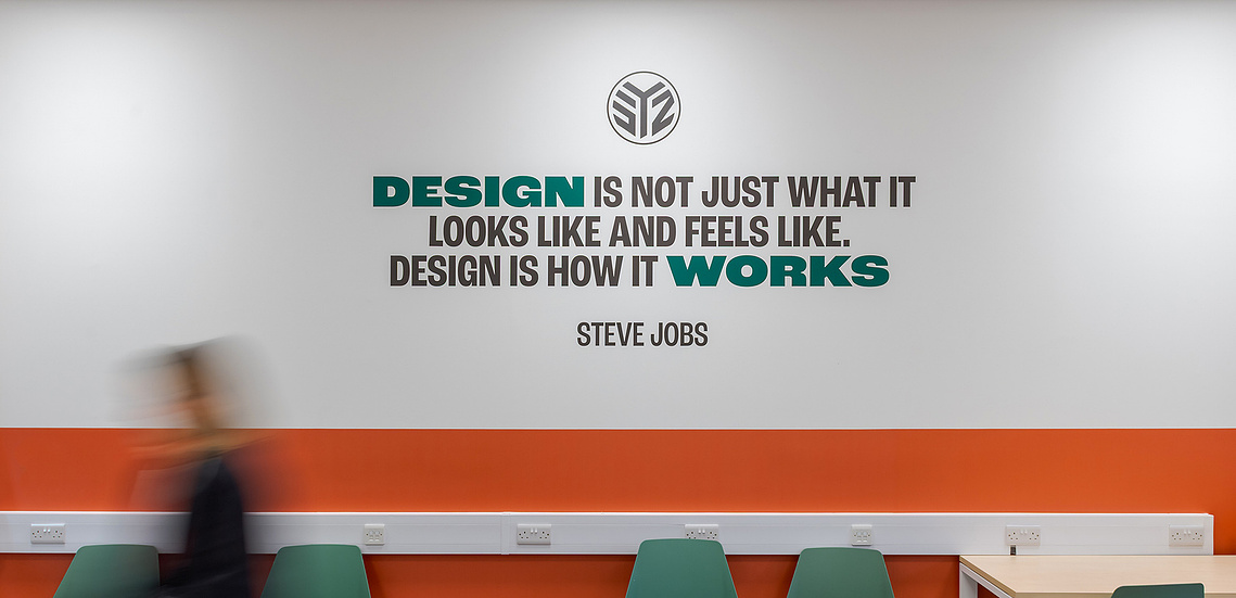 Detail shot by commercial interior photographer Manchester, showcasing a close up of high quality graphic installations for a creative portfolio. Quote on wall and person in foreground 