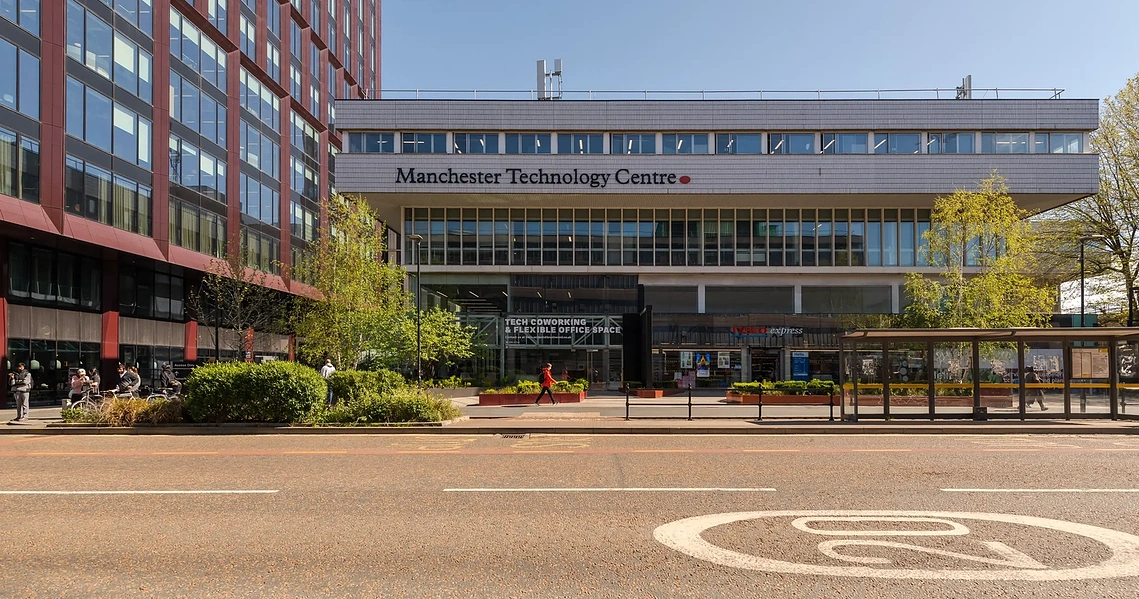 Sunlight illuminating the modern exterior facade of the Manchester School of Architecture.