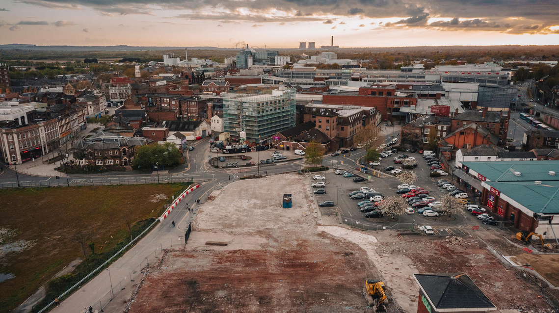 drone shot of cockhedge building site in warrington with view of power station chimneys in background