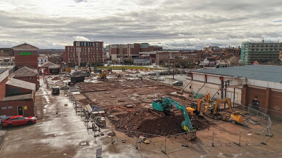 demolition site on shopping centre site, interior of building exposed by works. elevated shot shows wide construction site