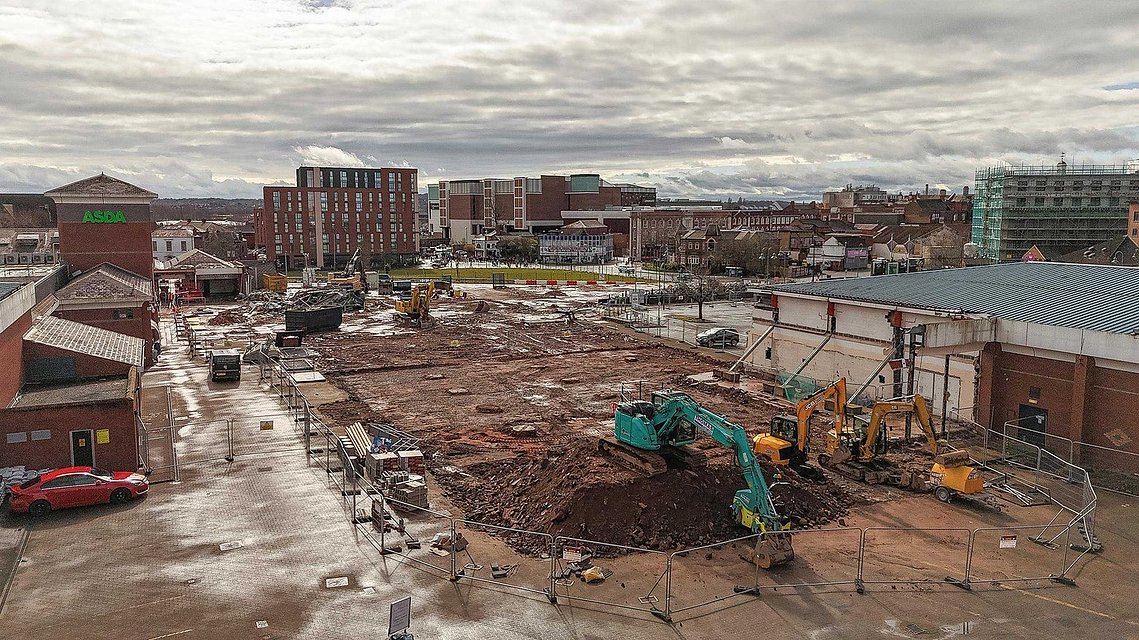 demolition site on shopping centre site, interior of building exposed by works. elevated shot shows wide construction site