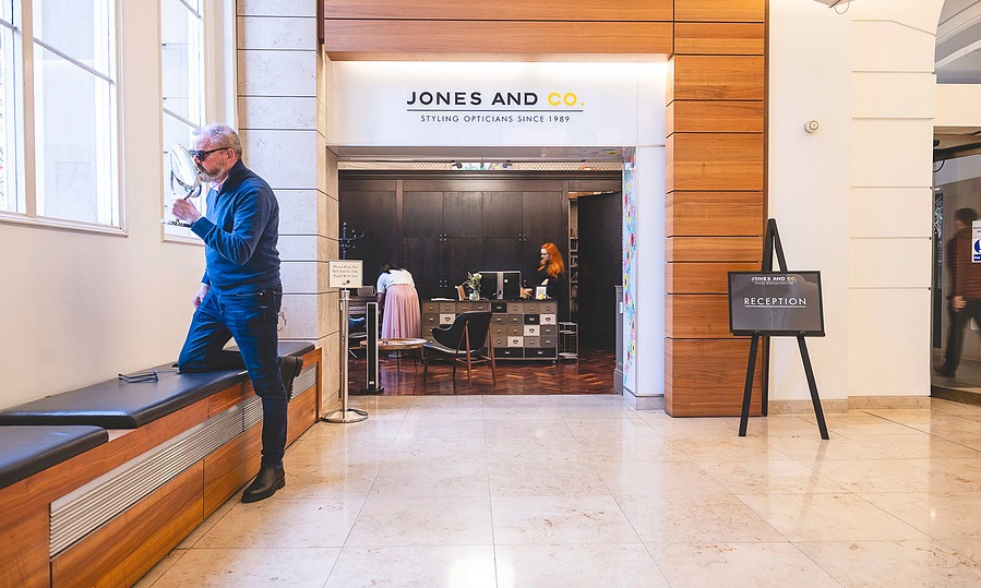 optician client tests frames in reception of building