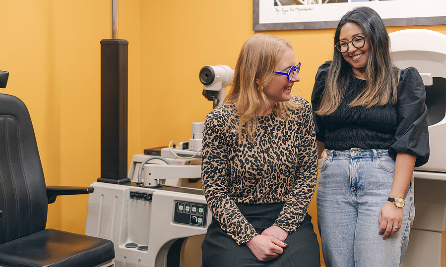two opticians in testing environment relax and smile