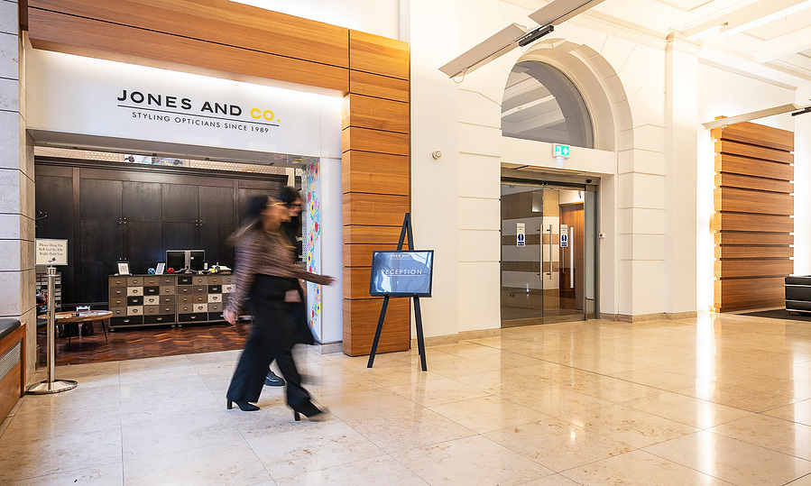 optician and client walk together in reception of building