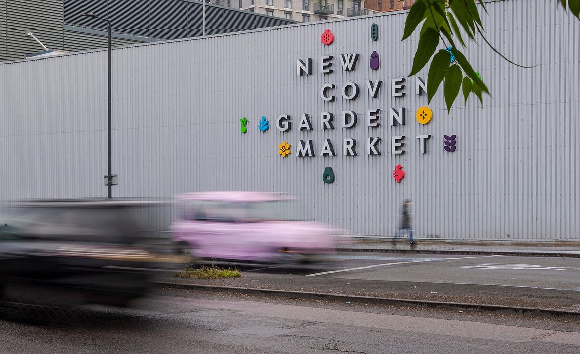 placemaking and lifestyle photography, london, battersea, street scene with cars and person walking past covent garden flower market sign