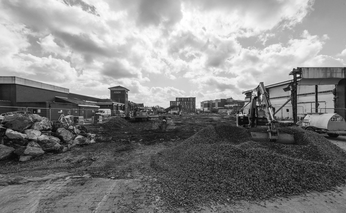 demolition works on site of shopping centre, black and white, diggers and rubble