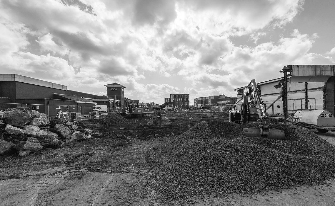 demolition works on site of shopping centre, black and white, diggers and rubble