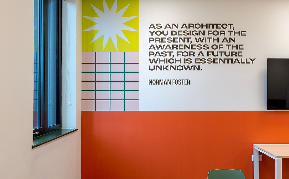 experiential design photography capturing the spatial layout and colourful wall branding with inspirational quote. architectural photography of interior spaces
