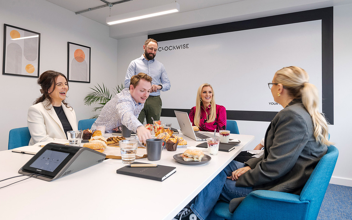 Authentic lifestyle photography of members working naturally at Clockwise workspace and enjoying catering options in meeting room