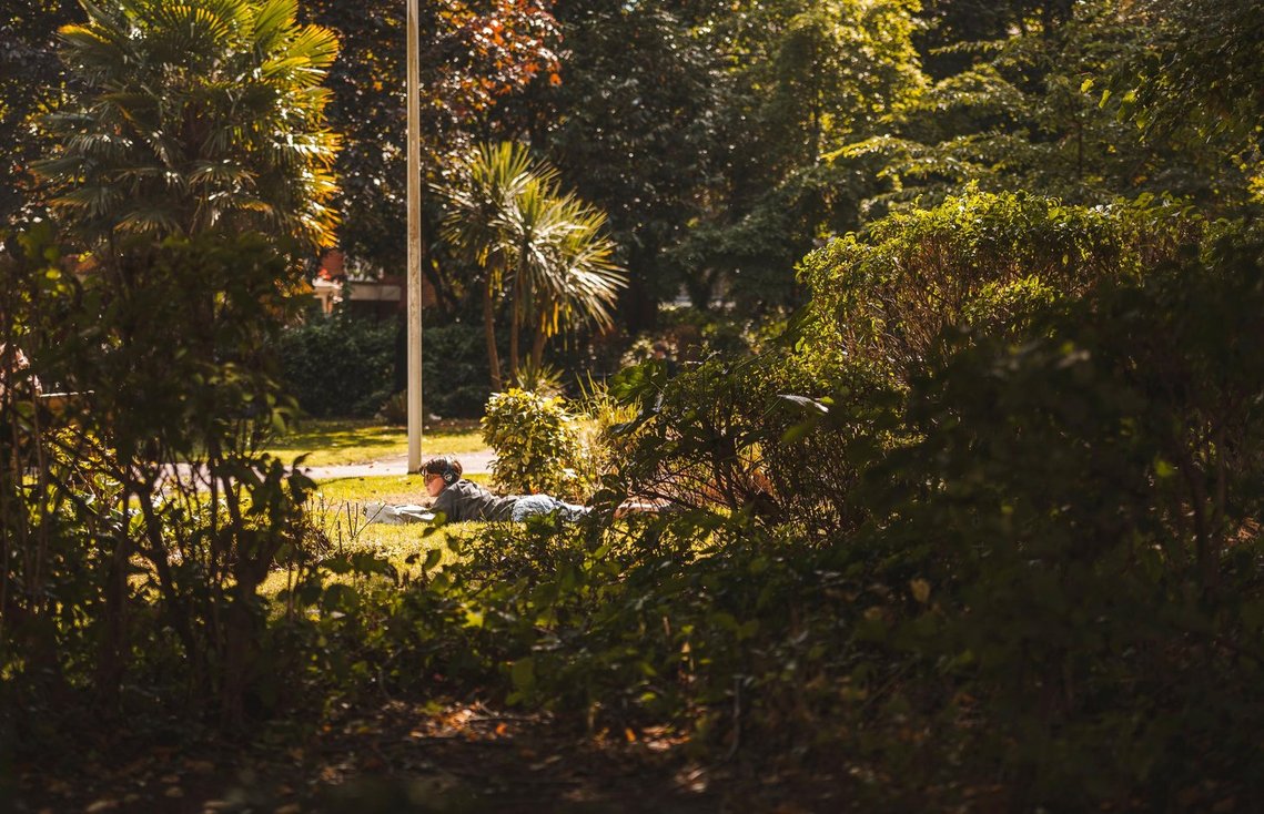 URBAN LIFESTYLE AND LOCAL AREA PHOTOGRAPHY OF SPINNINGFIELDS, MANCHESTER, lifestyle photography shows person relaxing in sunshine in a green space