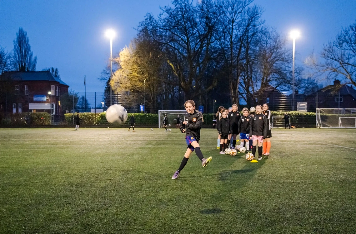 Documentary lifestyle photographer capturing sporting events at a practice pitch in Flixton. Girls shooting goals.