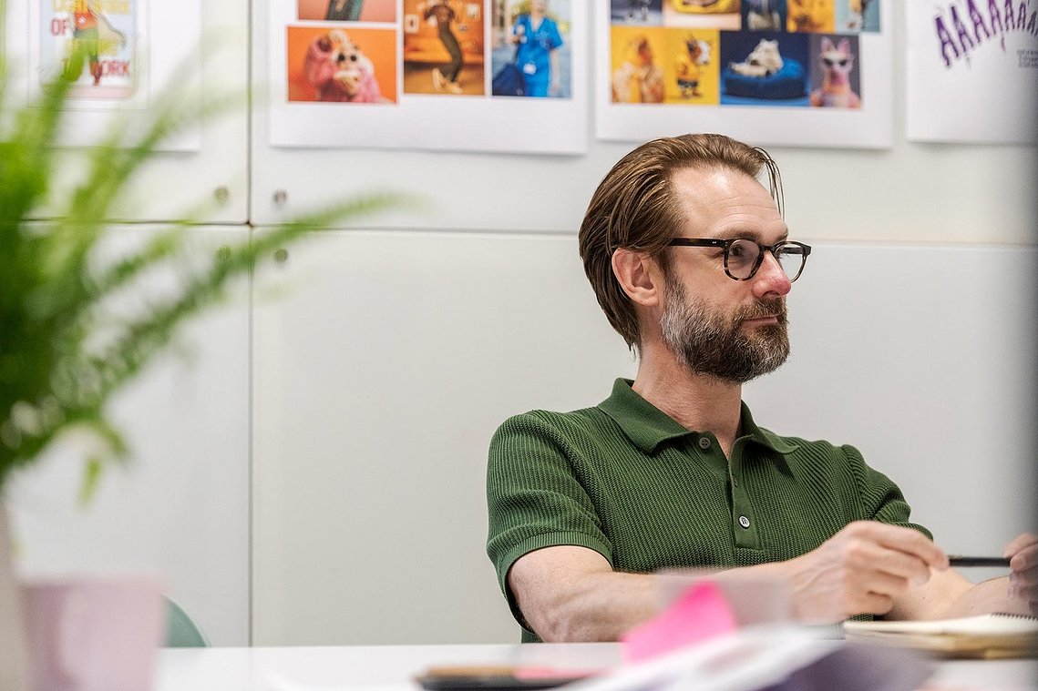 commercial lifestyle photography, candid portrait of team member sat at desk 