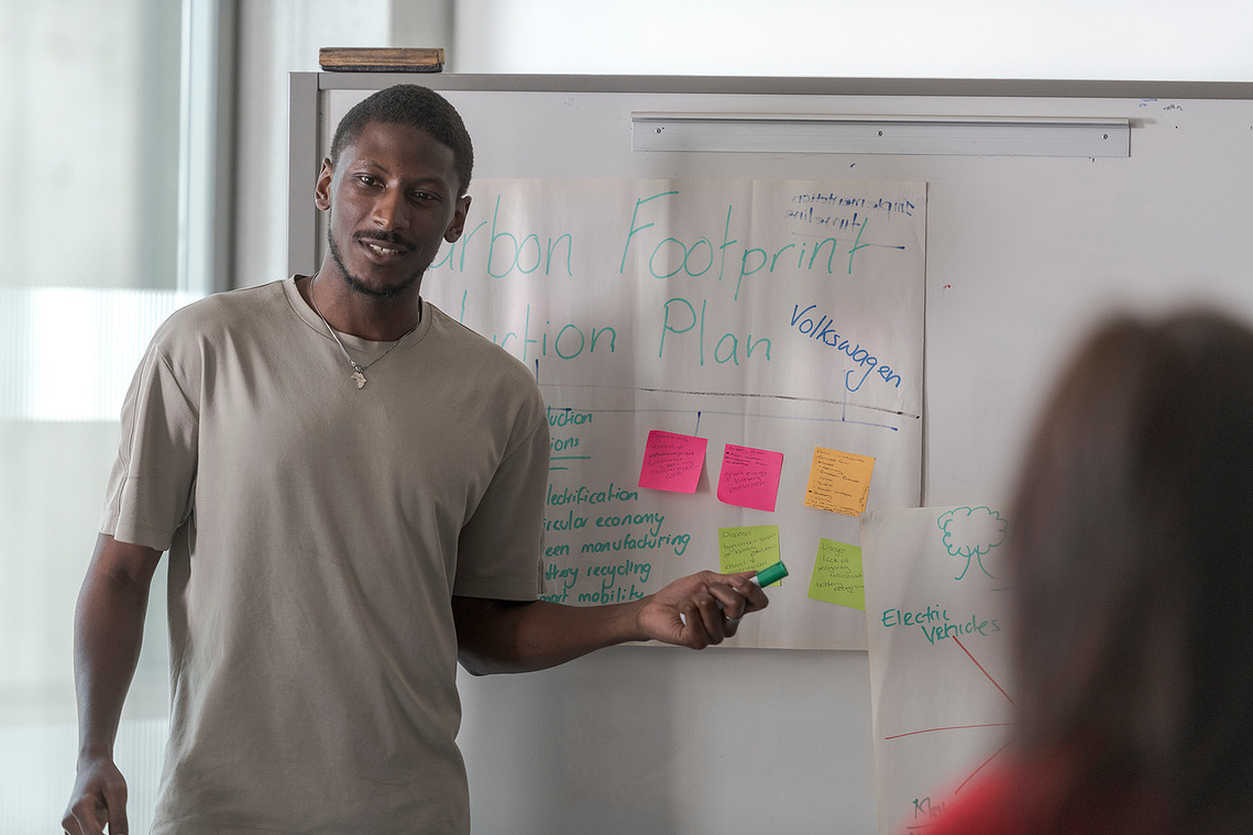 student presenting work on a flip chart with notes and stickies