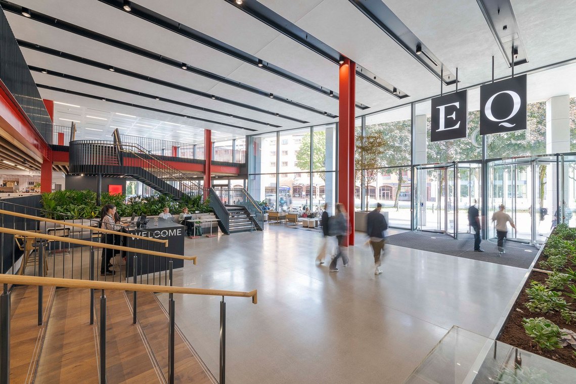 architecture photography of vast interior reception space in modern building with people walking through the frame