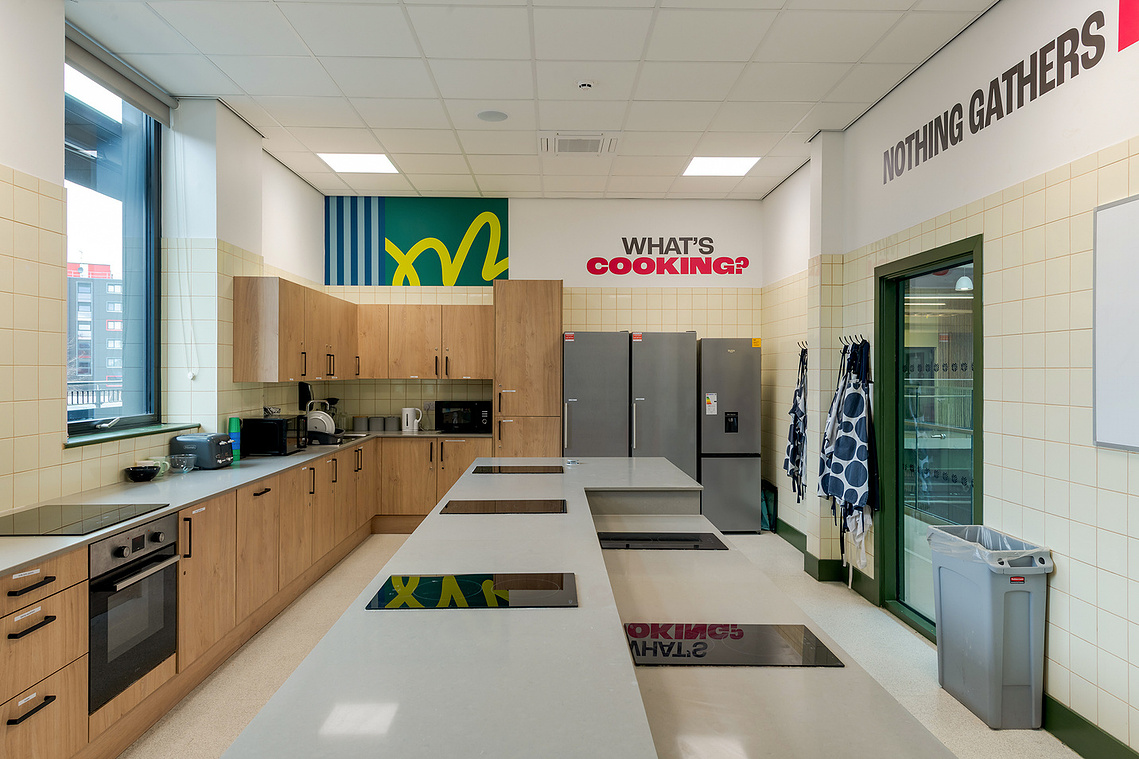 Architectural vinyl photography showcasing custom wall graphics and inspirational quotes installed on a commercial interior wall, specifically a kitchen room
