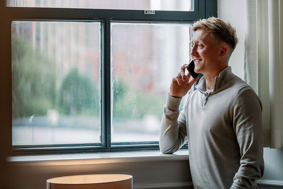Commercial lifestyle photography in Manchester. Portrait of man on phone next to window