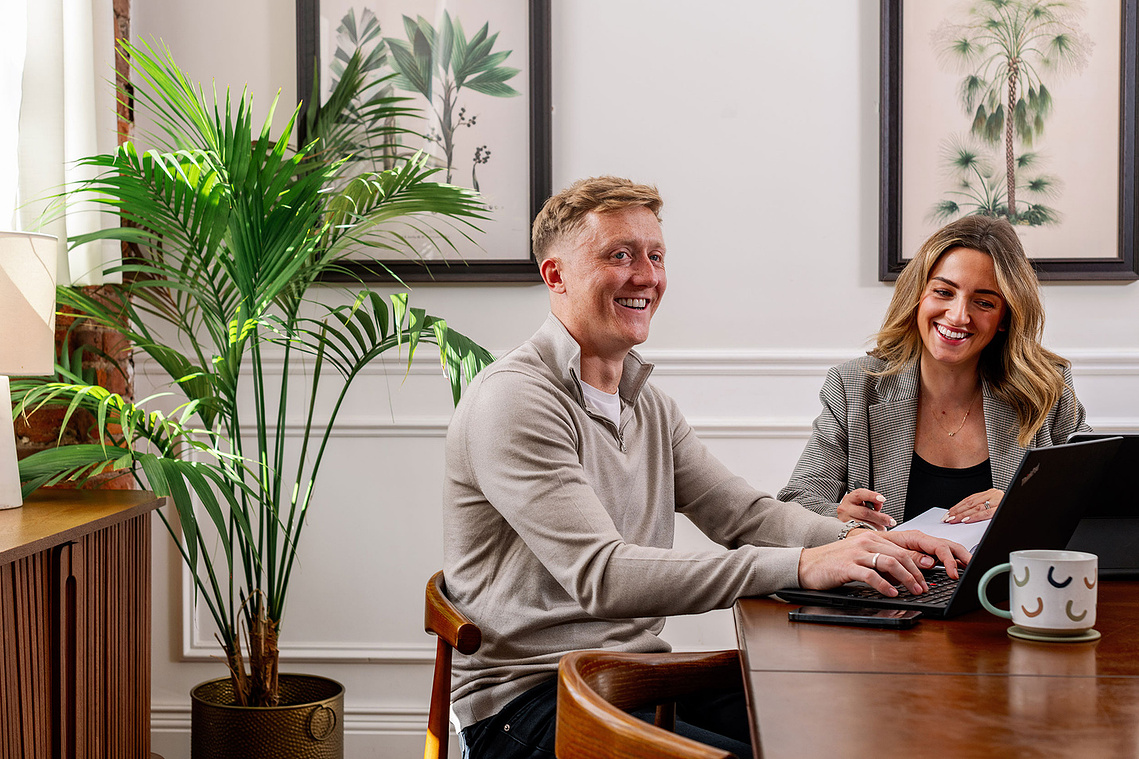 Lifestyle brand photography shoot at Beehive Lofts Manchester. Man and woman on laptop smiling in office space