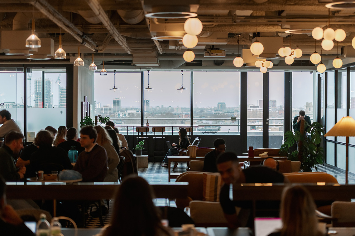 Commercial lifestyle photography team collaboration London office, view of wide office space with London skyline in background

