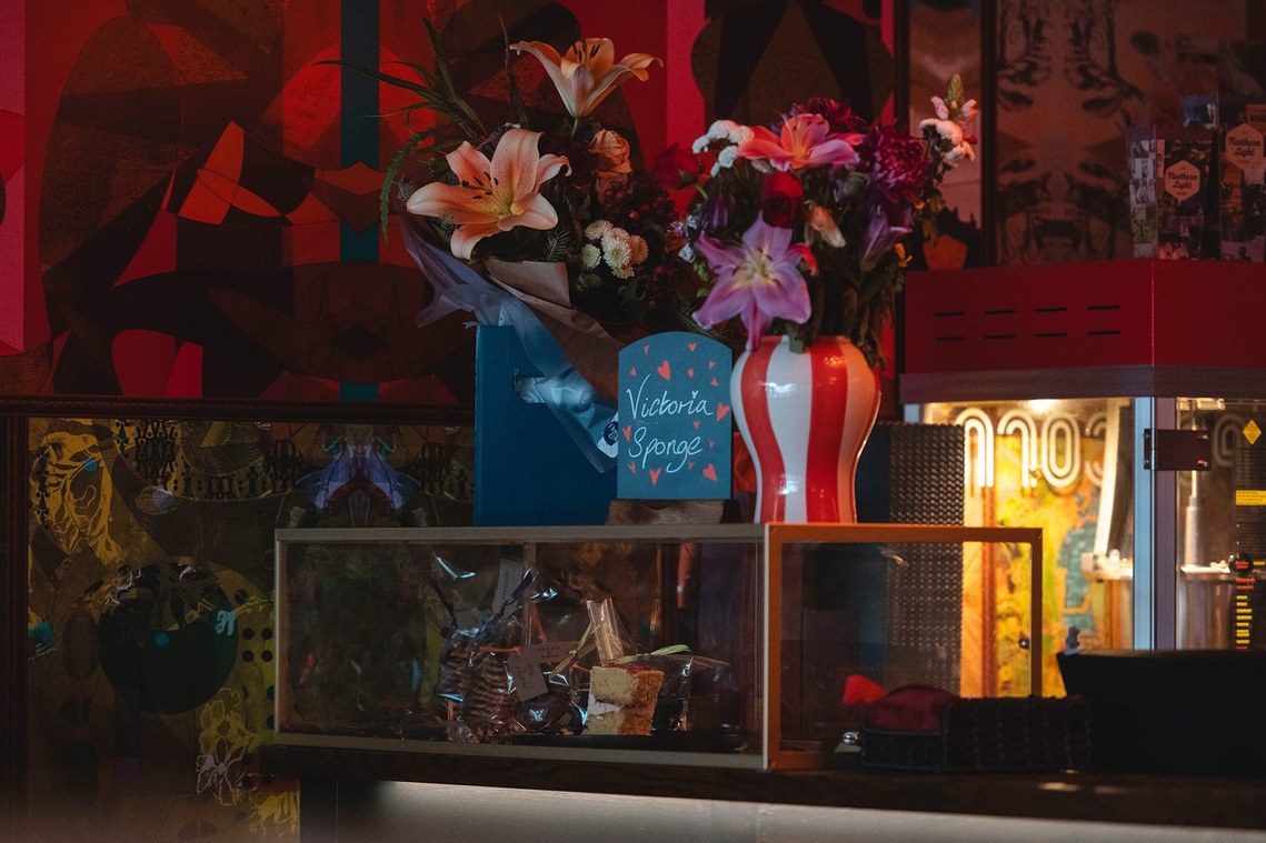photo of cinema reception, with colourful display including a popcorn machine and flowers