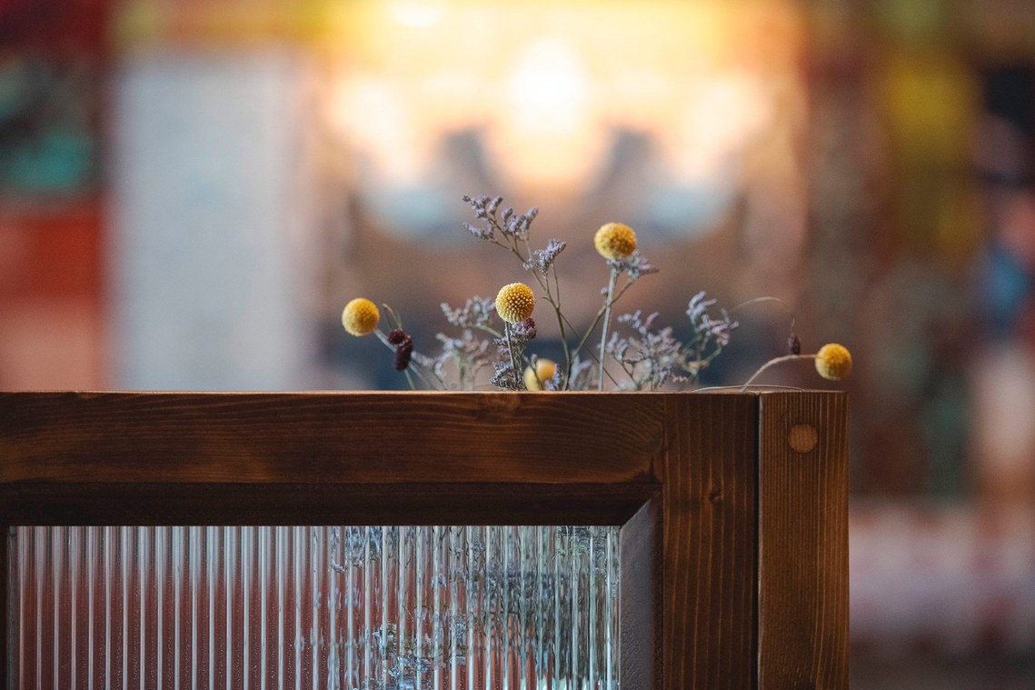 detail shot showing glass panel with flowers behind, background blurred
