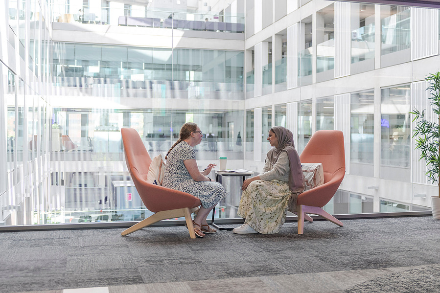 student lifestyle photography and education photography, one to one between tutor and student, sat in arm chairs against a glass wall