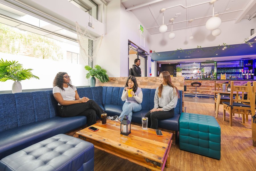 student lifestyle photography, wide shot of students at in a bar area on campus