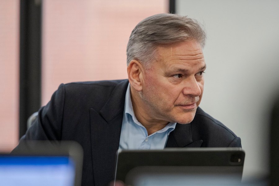 A man in a suit sits at a table captured perfectly by a Manchester commercial photographer known for relaxed corporate photography.