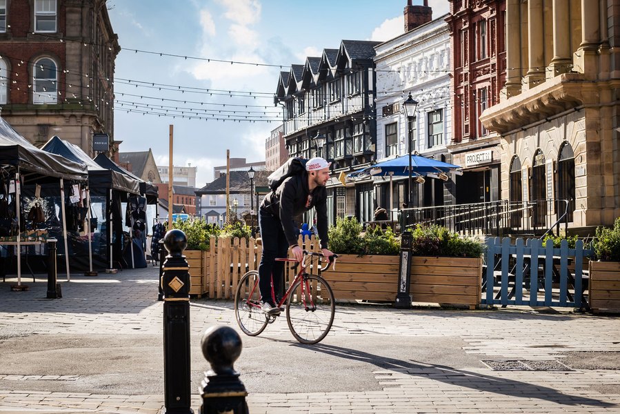 stockport lifestyle and placemaking photography, local street architecture, cyclist, sunny day