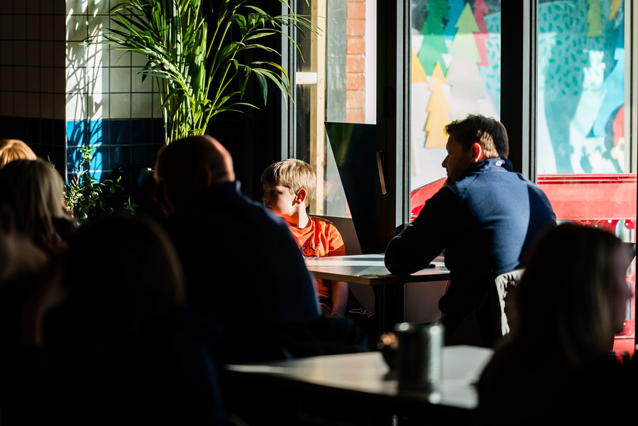 Placemaking and lifestyle photography,
Leisure and hospitality destination,
Customers sat inside cafe lit by sunlight