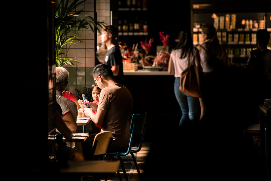Placemaking and lifestyle photography,
Leisure and hospitality destination,
Customers sat inside cafe lit by sunlight