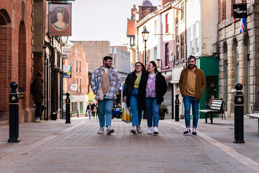 group of young people walking through stockport underbanks streets 