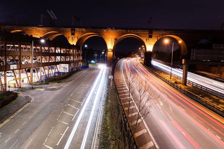stockport lifestyle and placemaking photography, local street architecture, evening shot, long exposure shows traffic passing under viaduct