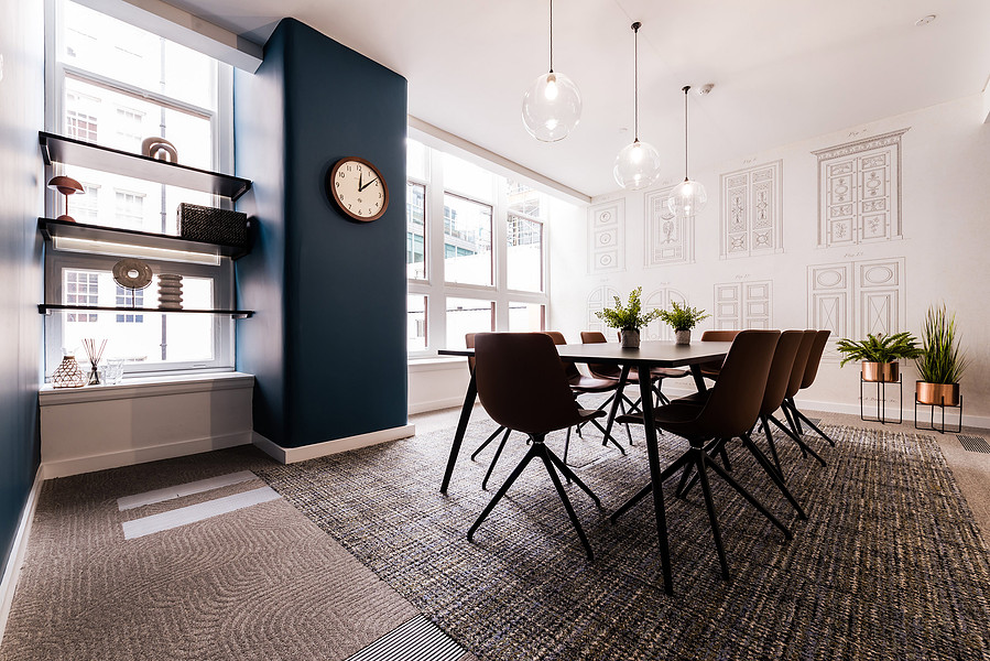Meeting room in refurbished manchester office building. modern design with blue walls and wooden floor.