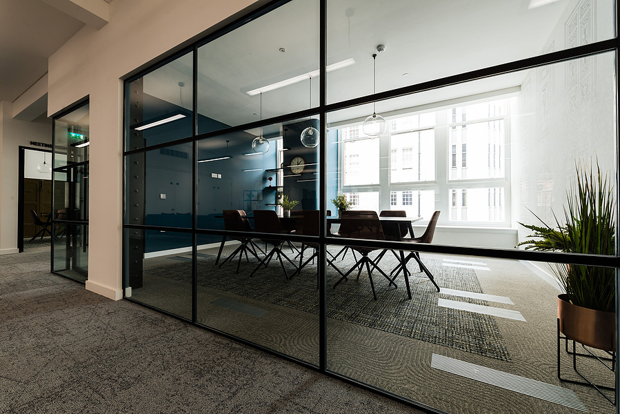 photograph looking into Meeting room in refurbished manchester office building. modern design with blue walls and wooden floor.